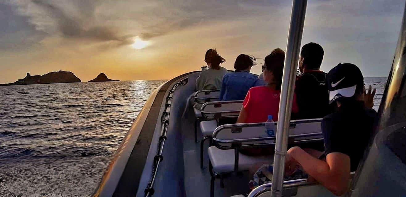 Passengers on speedboat at sunset cruising coastal waters