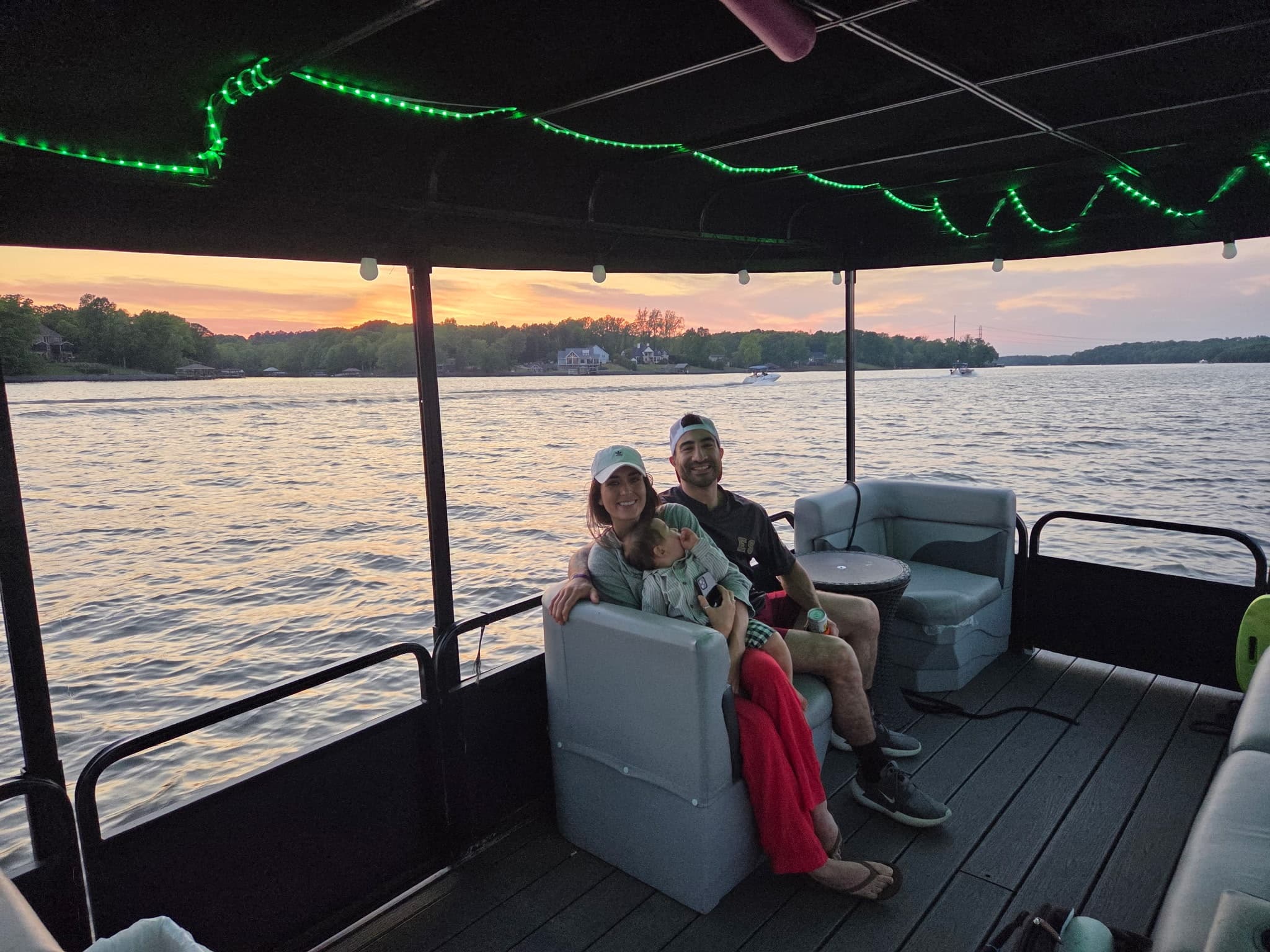 Couple relaxing on pontoon boat at sunset on scenic lake