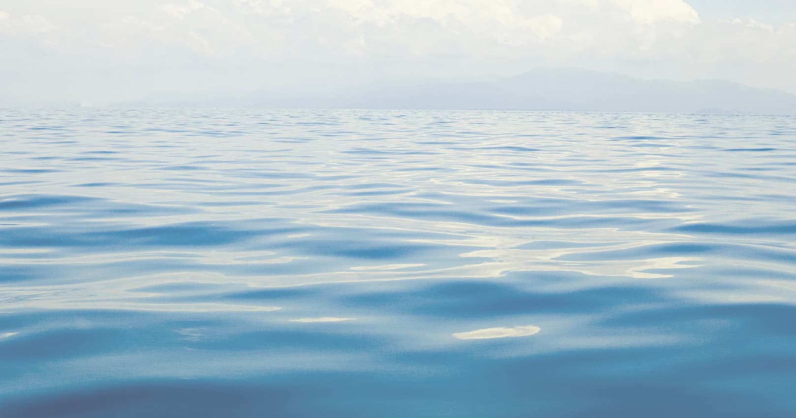 Calm open ocean horizon with gentle waves, peaceful seascape