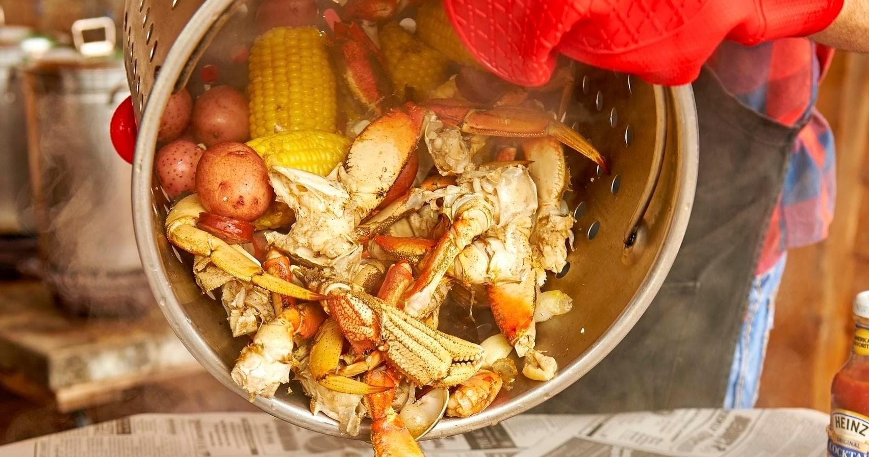 Seafood boil with crab, corn, potatoes at outdoor camp feast