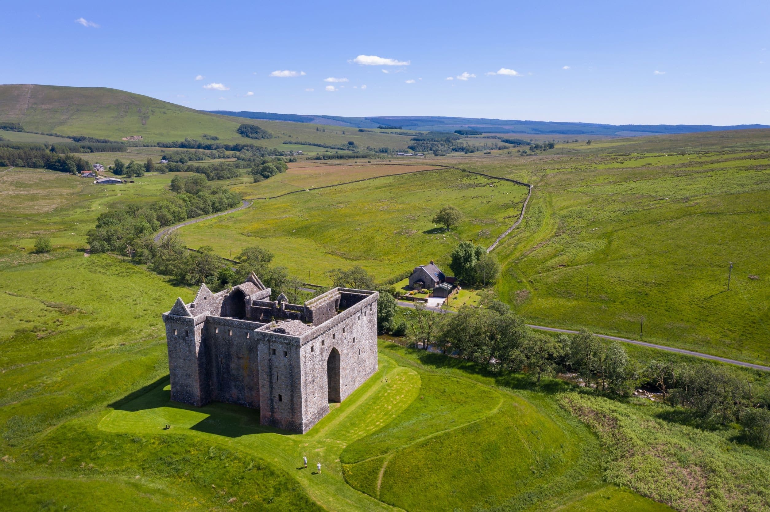 Aerial view of hilltop castle over rolling green countryside
