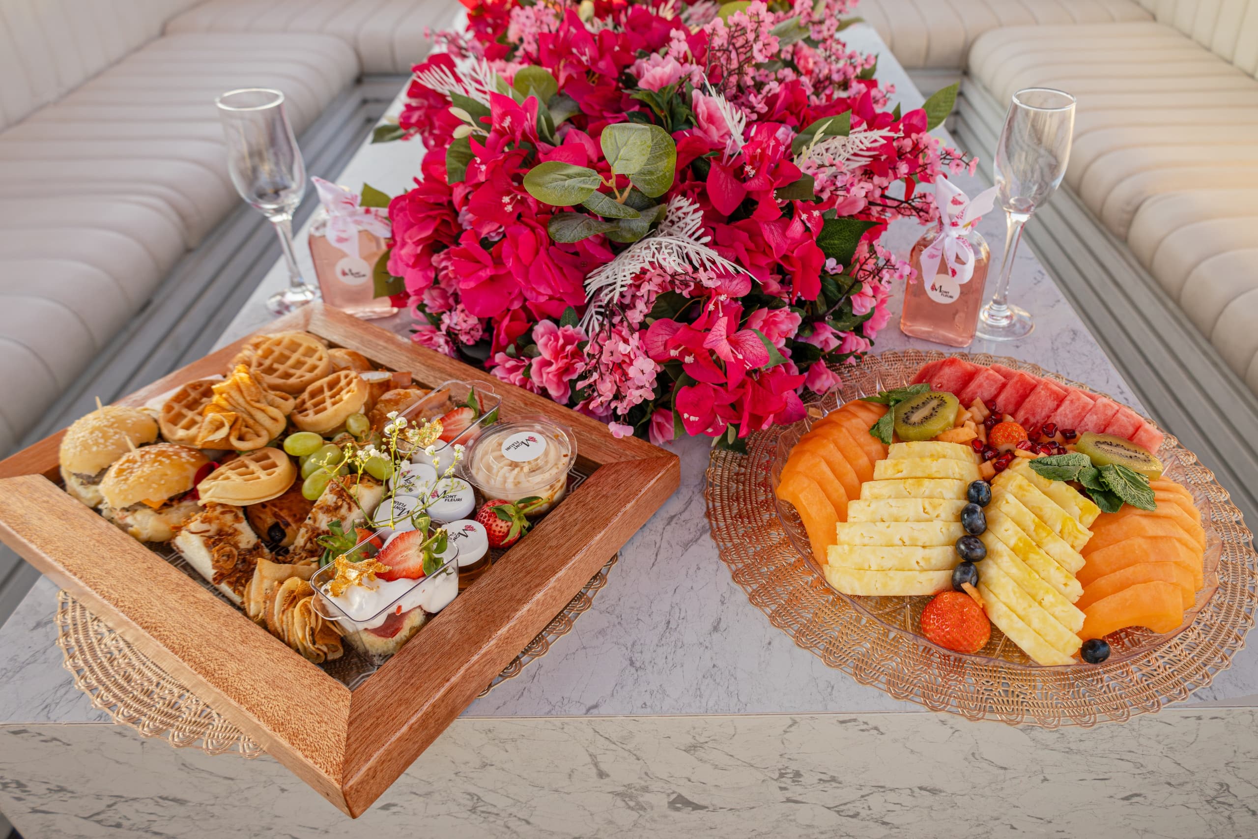 Gourmet picnic spread on yacht table with floral centerpiece onboard