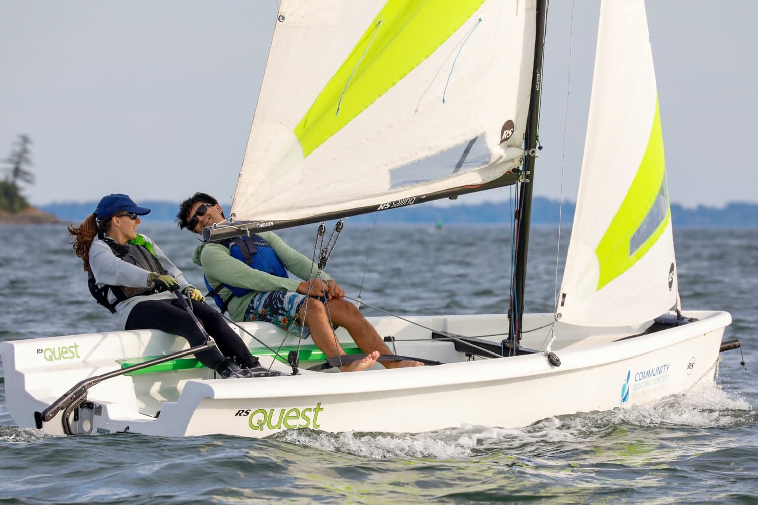 Two-person sailboat racing on open water, coastal sailing adventure