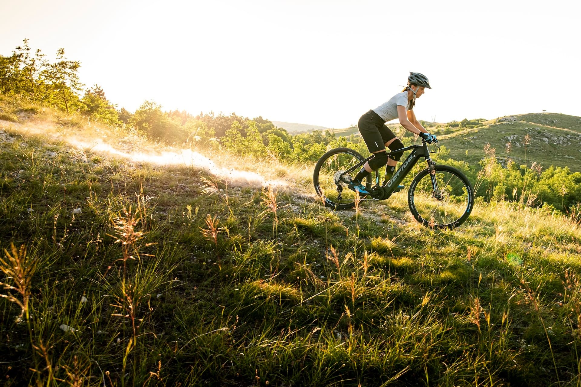 Mountain biker riding golden trail at sunset in countryside