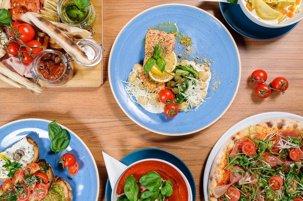 Plated Polish cuisine and pizza spread at indoor dining table