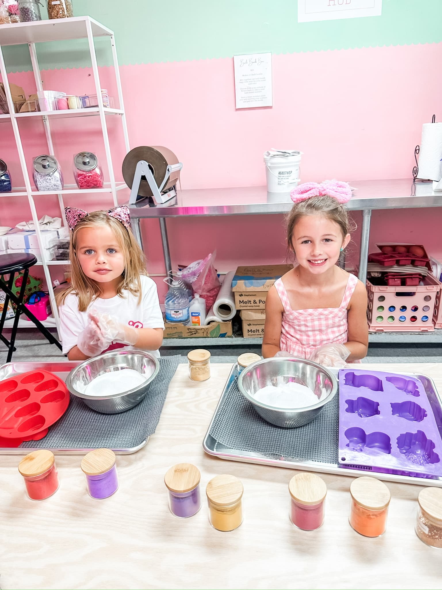 Children pouring soap mixture into silicone molds in studio