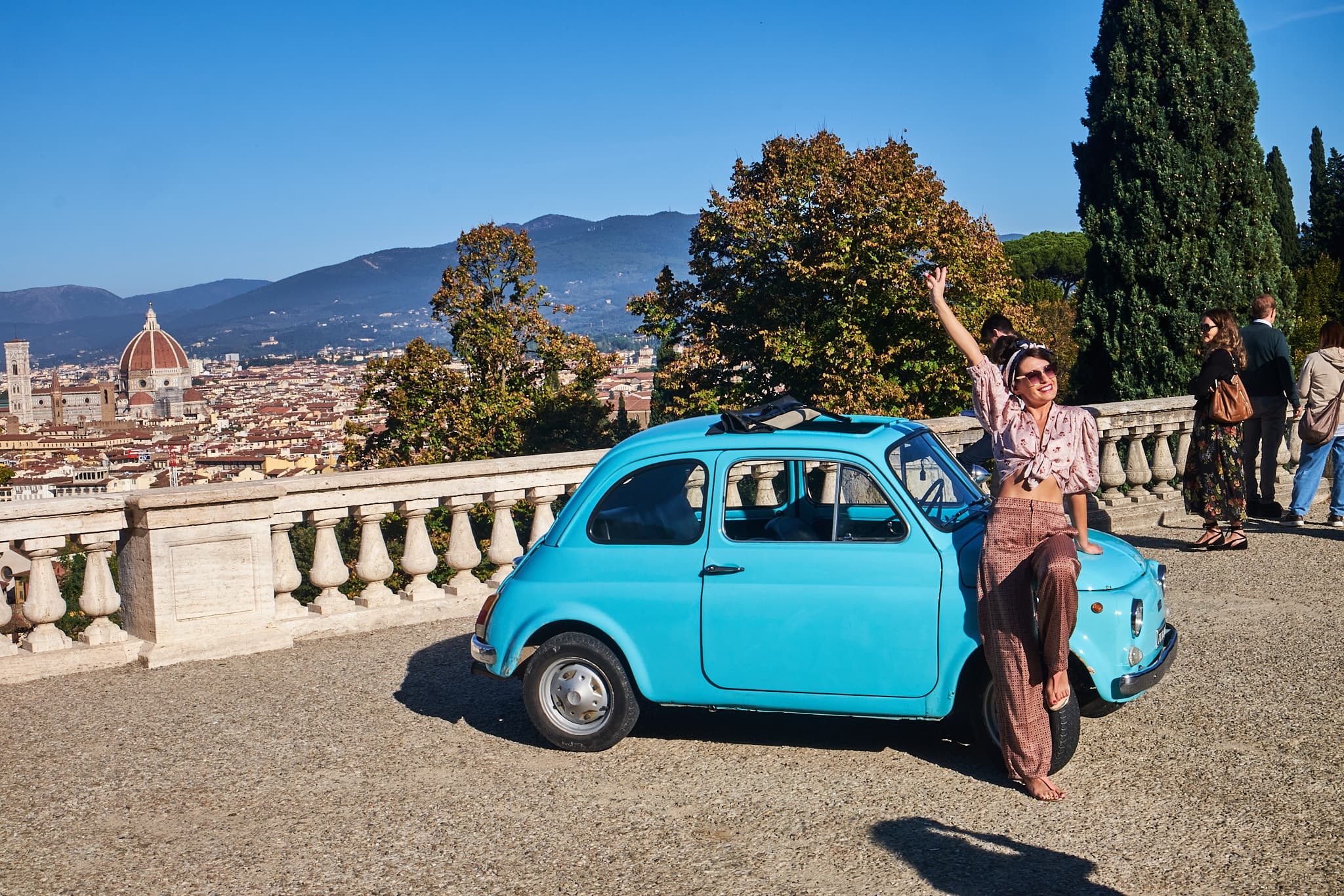 Vintage turquoise Fiat with Florence skyline overlooks Tuscany