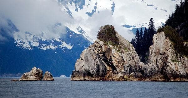 Rocky coastal islands with snowcapped peaks and calm Alaska waters
