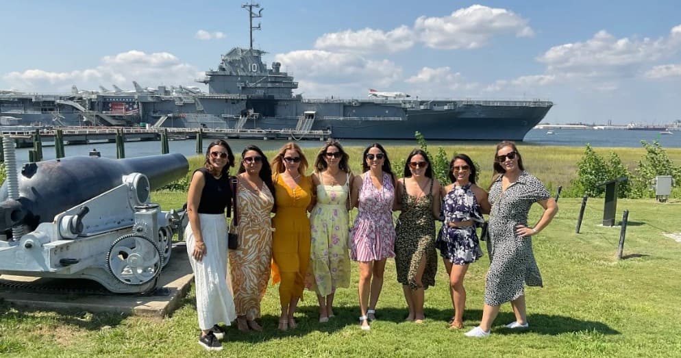 Tour group posing near USS Yorktown aircraft carrier at Patriots Point