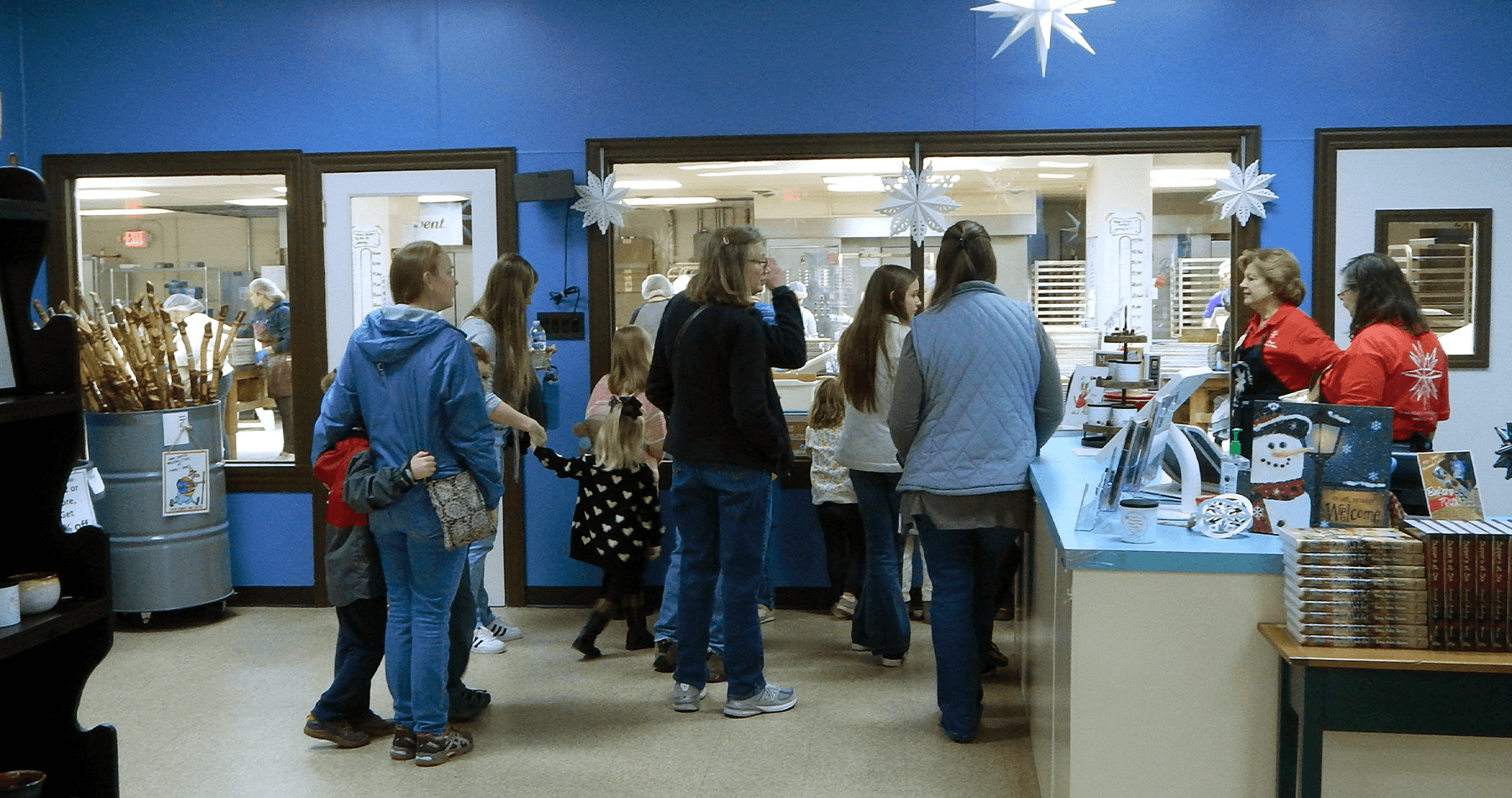 Customers queuing and browsing cookies inside an indoor bakery shop
