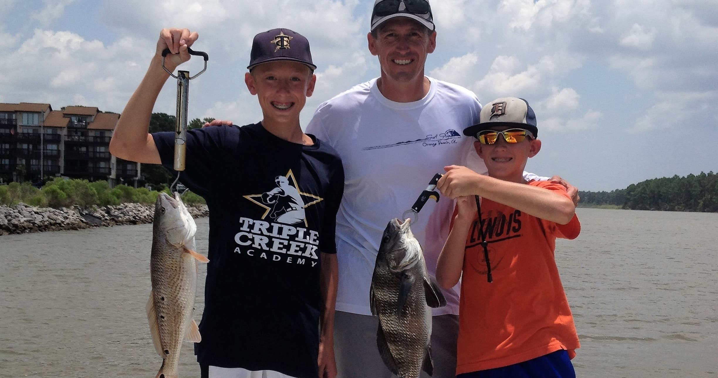 Family anglers holding speckled trout on coastal inshore trip
