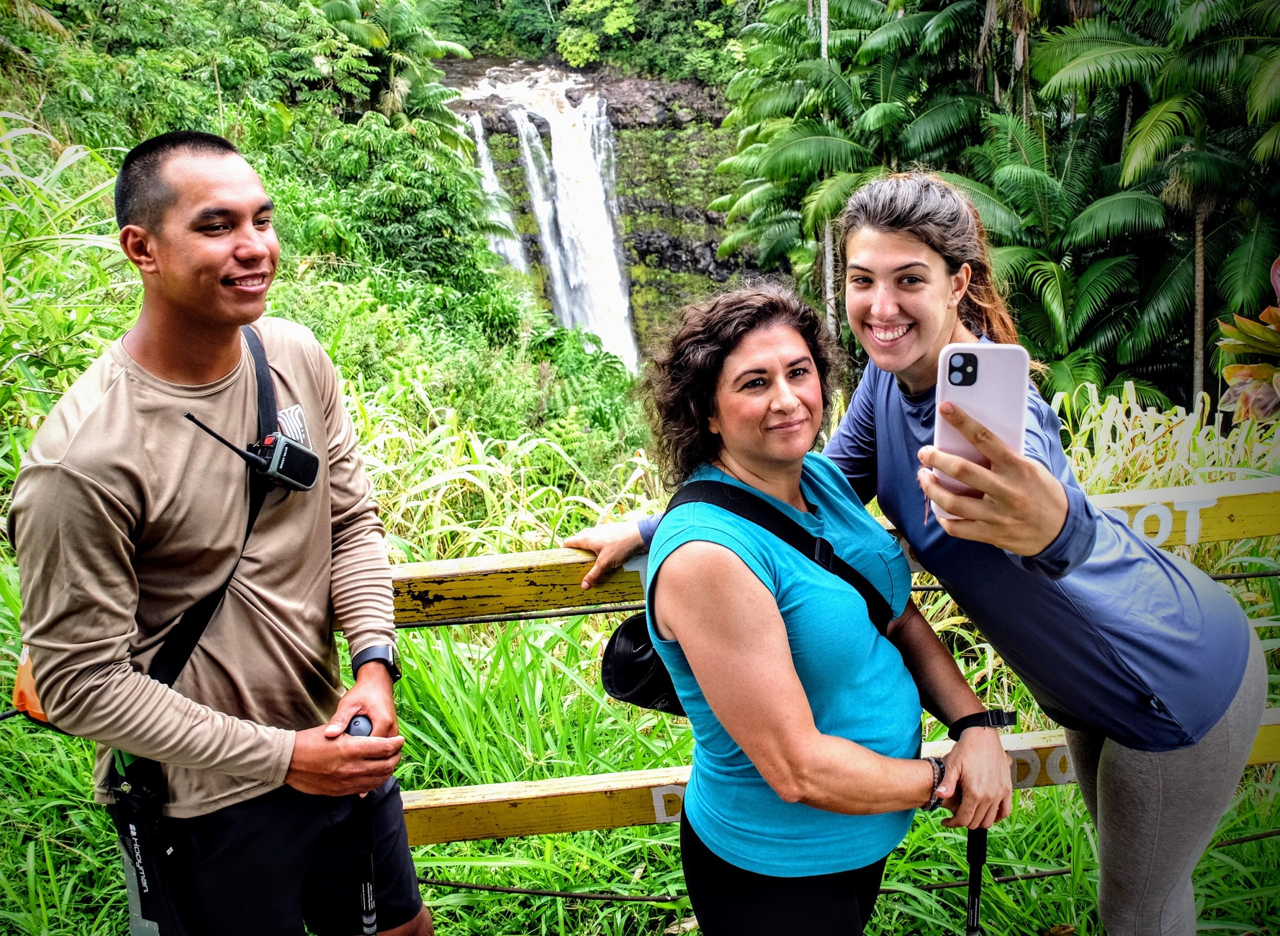 Tour participants taking selfie at tropical waterfall vista in Hawaii