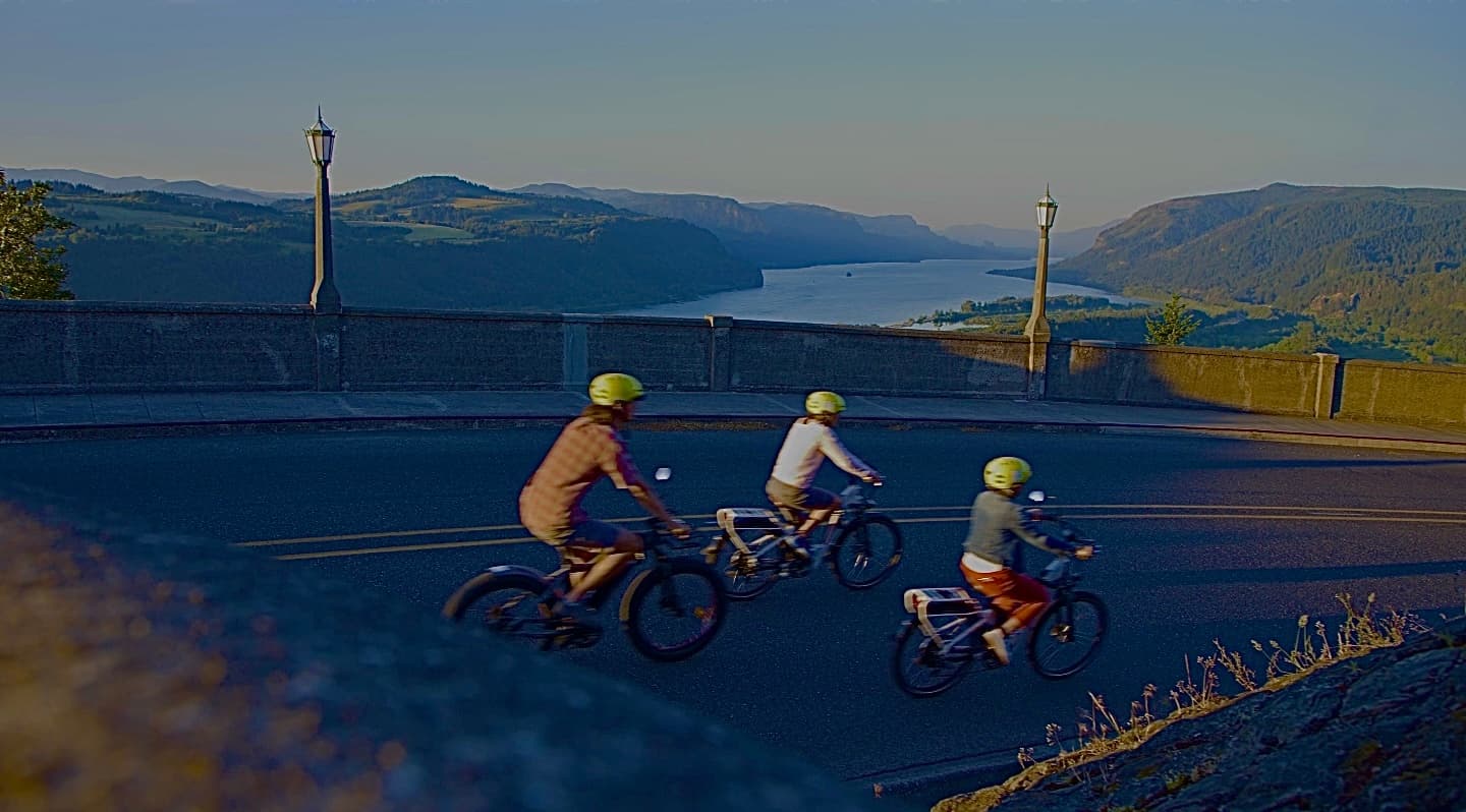 Family e-bike riders at Columbia River Gorge overlook at sunset