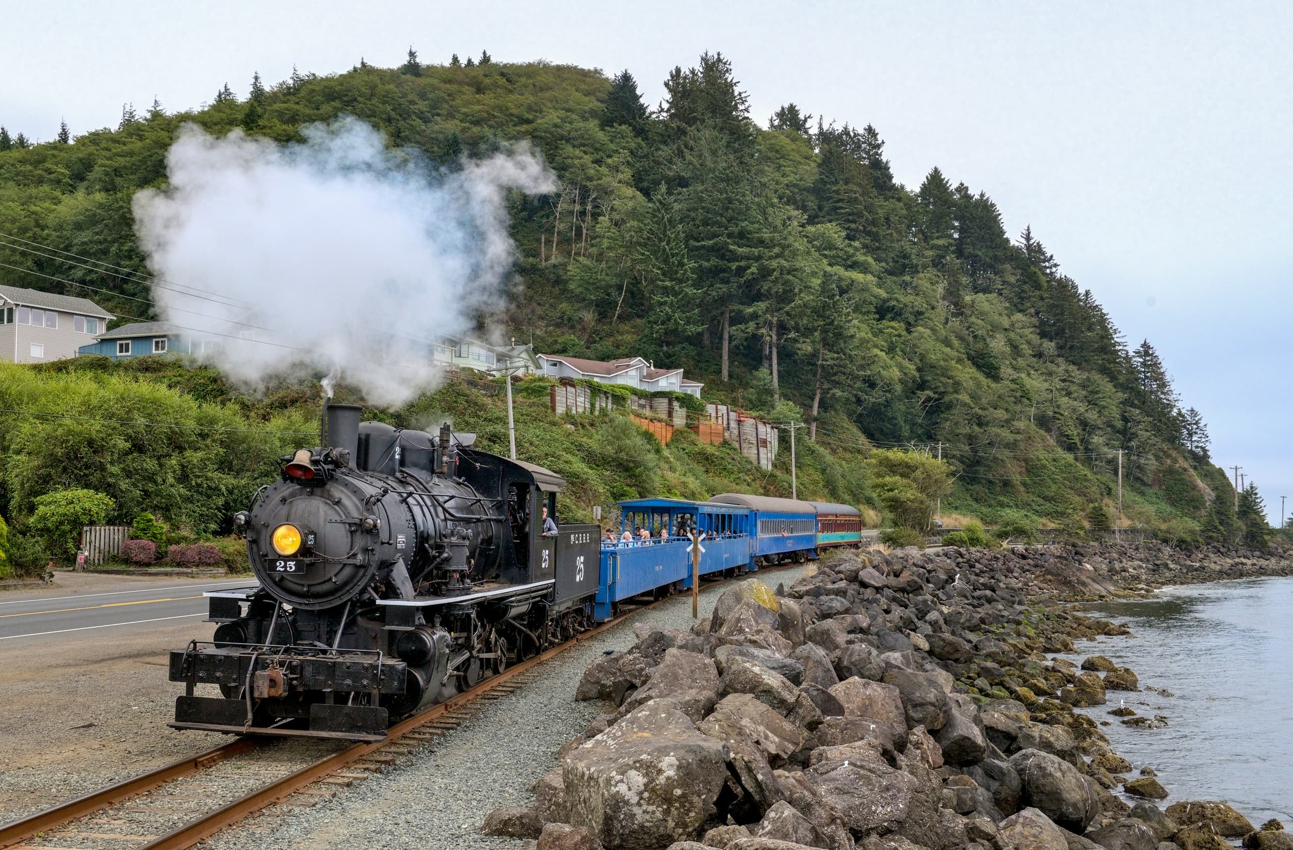 Steam train hugging rocky shoreline on the Oregon Coast