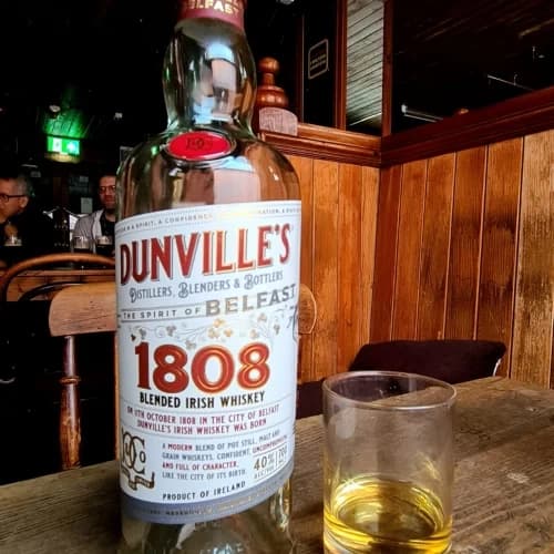 Bottle of Dunville's 1808 Irish whiskey on pub table Belfast