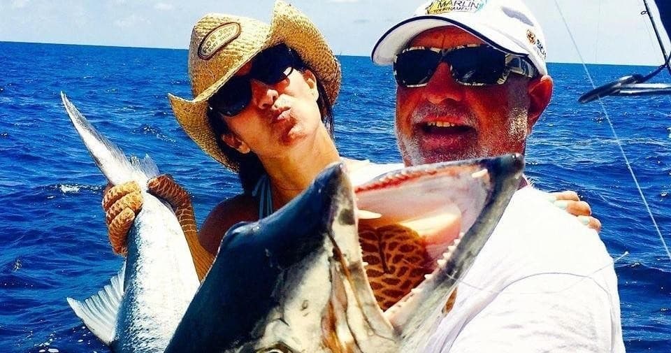 Couple posing with multiple caught fish aboard offshore sportfishing boat