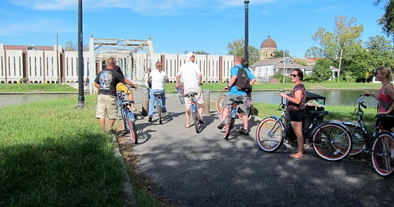 Bike tour group riding near historic museum grounds in New Orleans