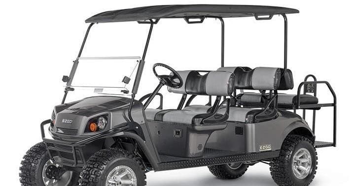 Four-passenger golf cart parked, rugged tires for beach rides