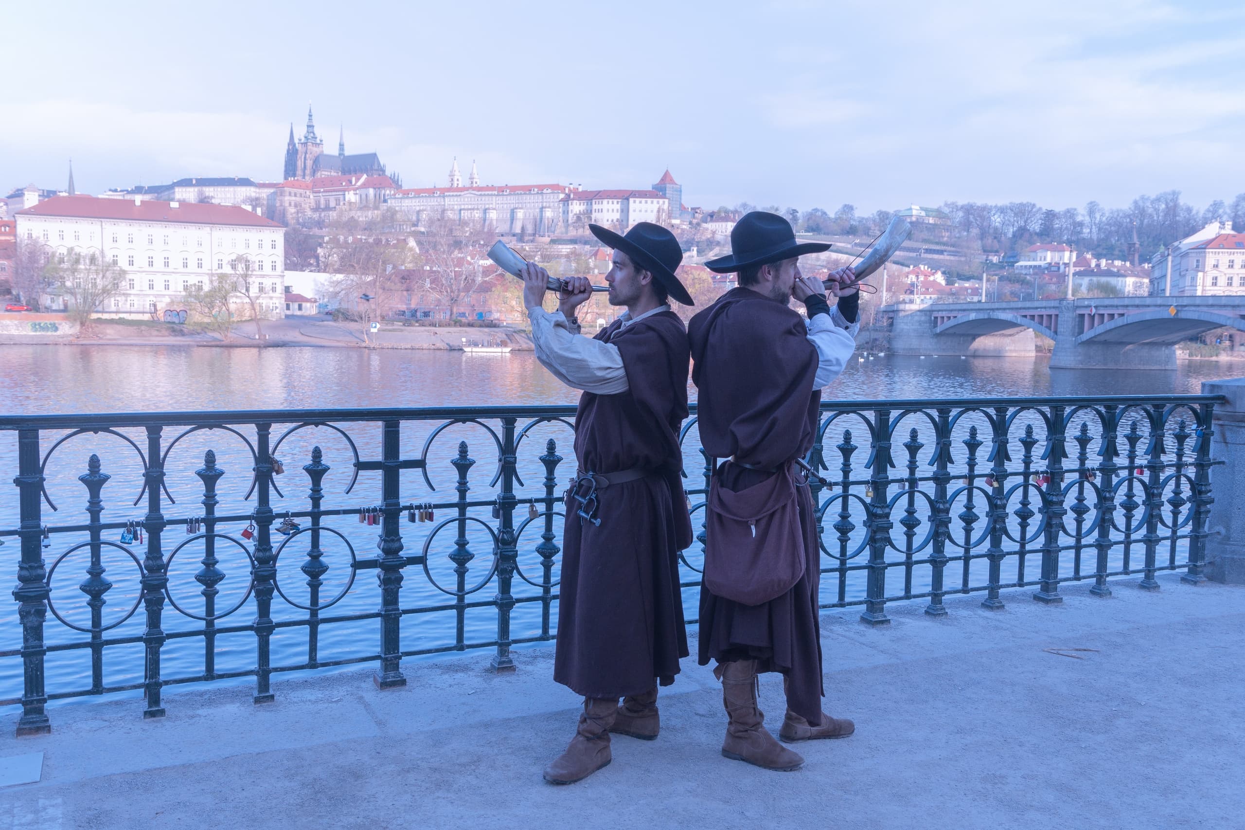 Historic night watchmen blowing horns along Prague riverfront