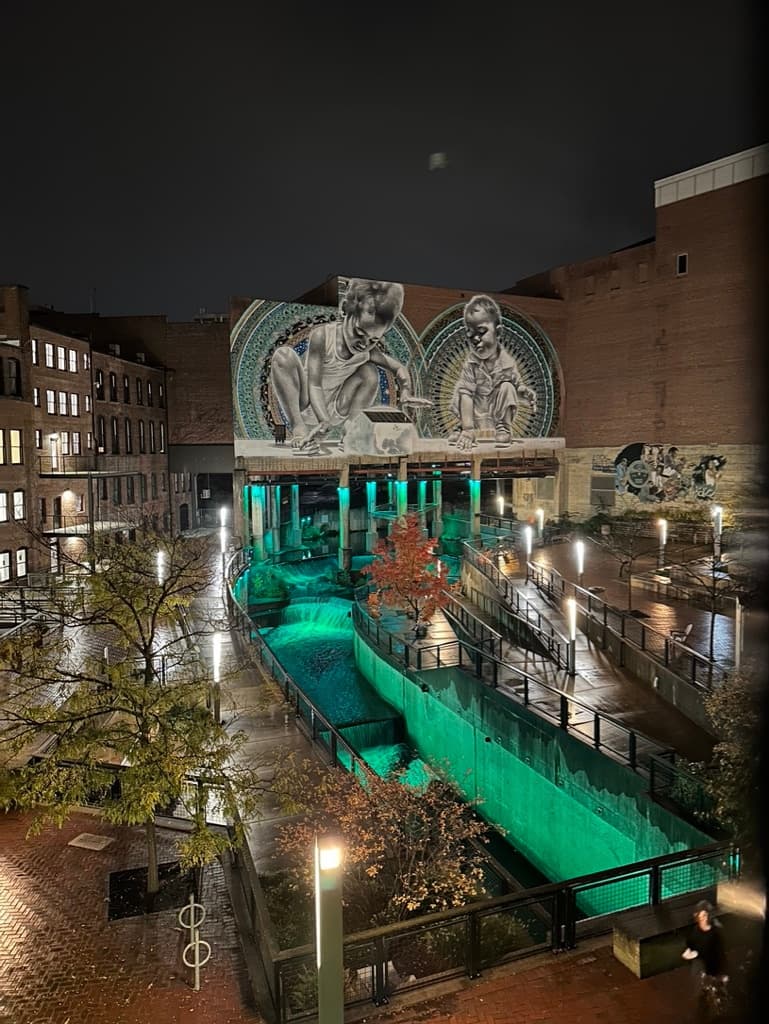 Nighttime urban mural and illuminated canal walkway in downtown
