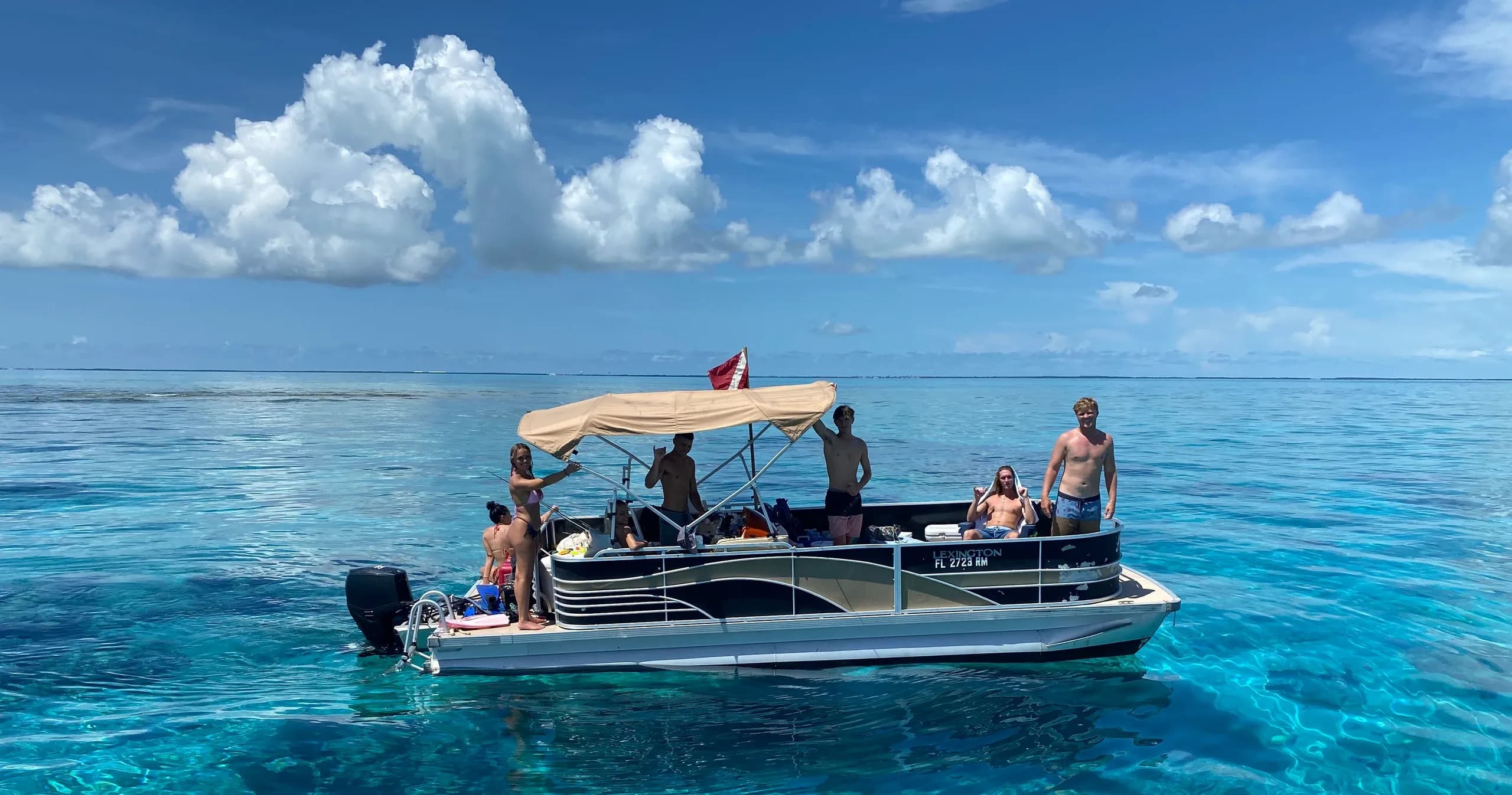 Pontoon boat with guests on turquoise open ocean, scenic snorkeling trip
