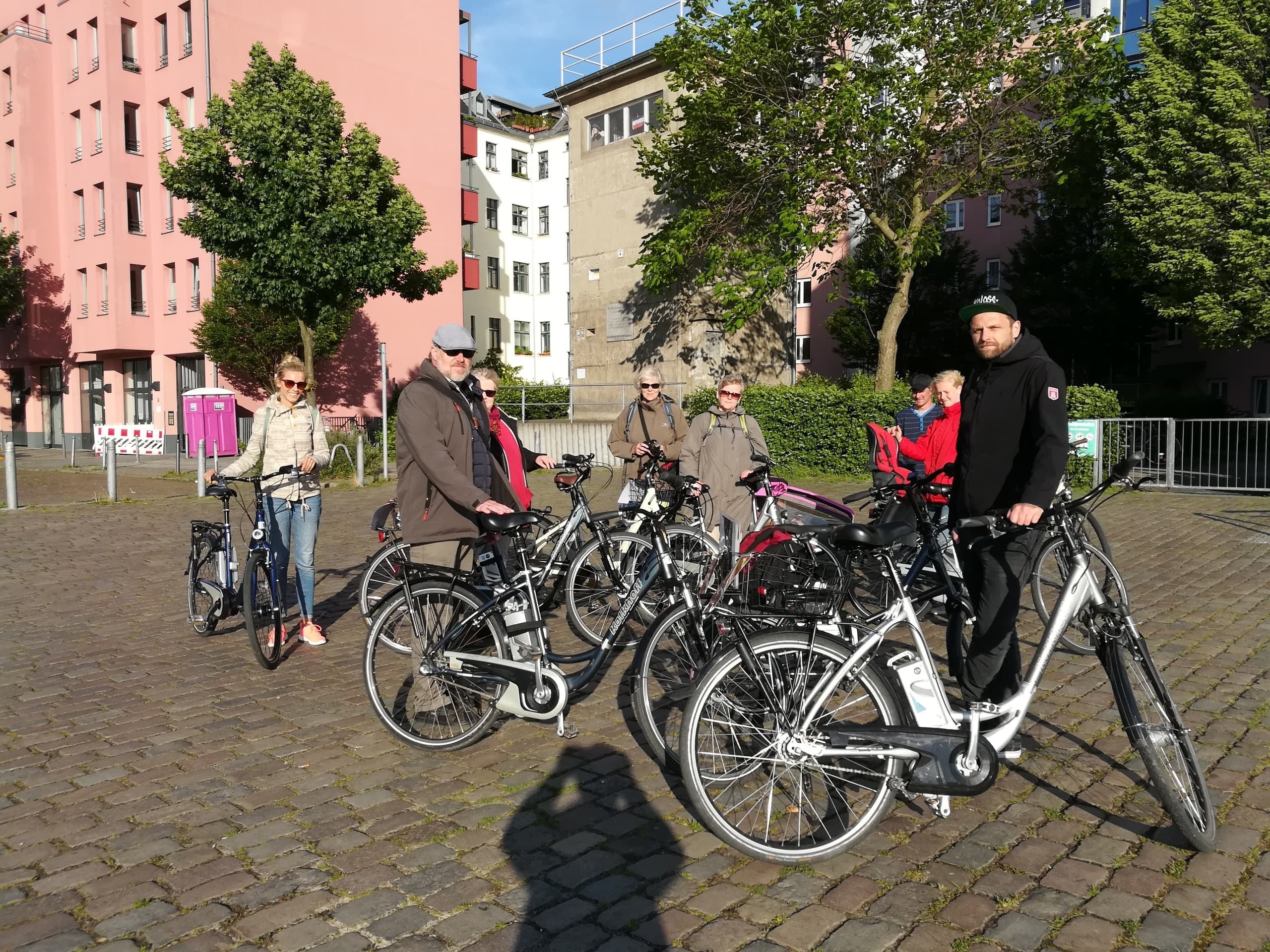 Group of cyclists on e-bikes touring Berlin cobblestone plaza