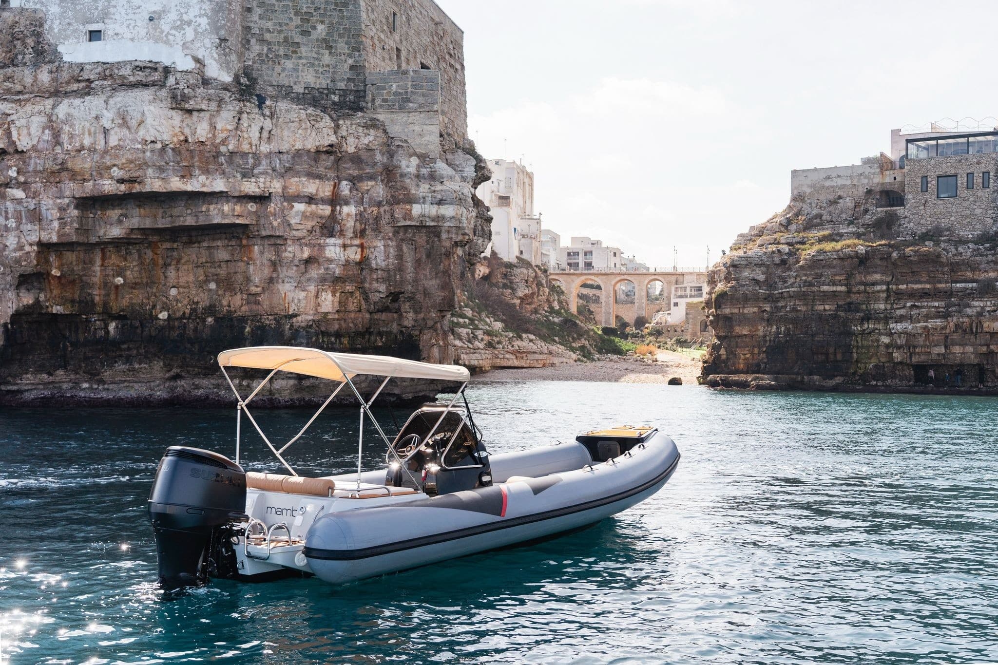 Rigid inflatable boat cruising near coastal cliffs and inlet