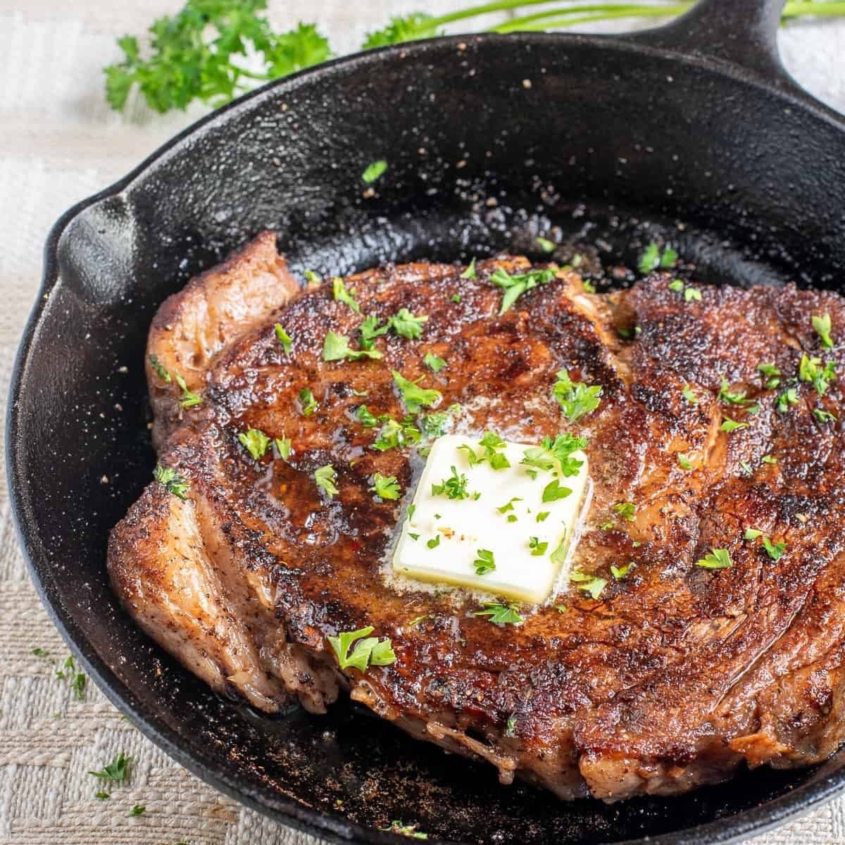 Cast-iron seared steak with herb butter in New Orleans kitchen