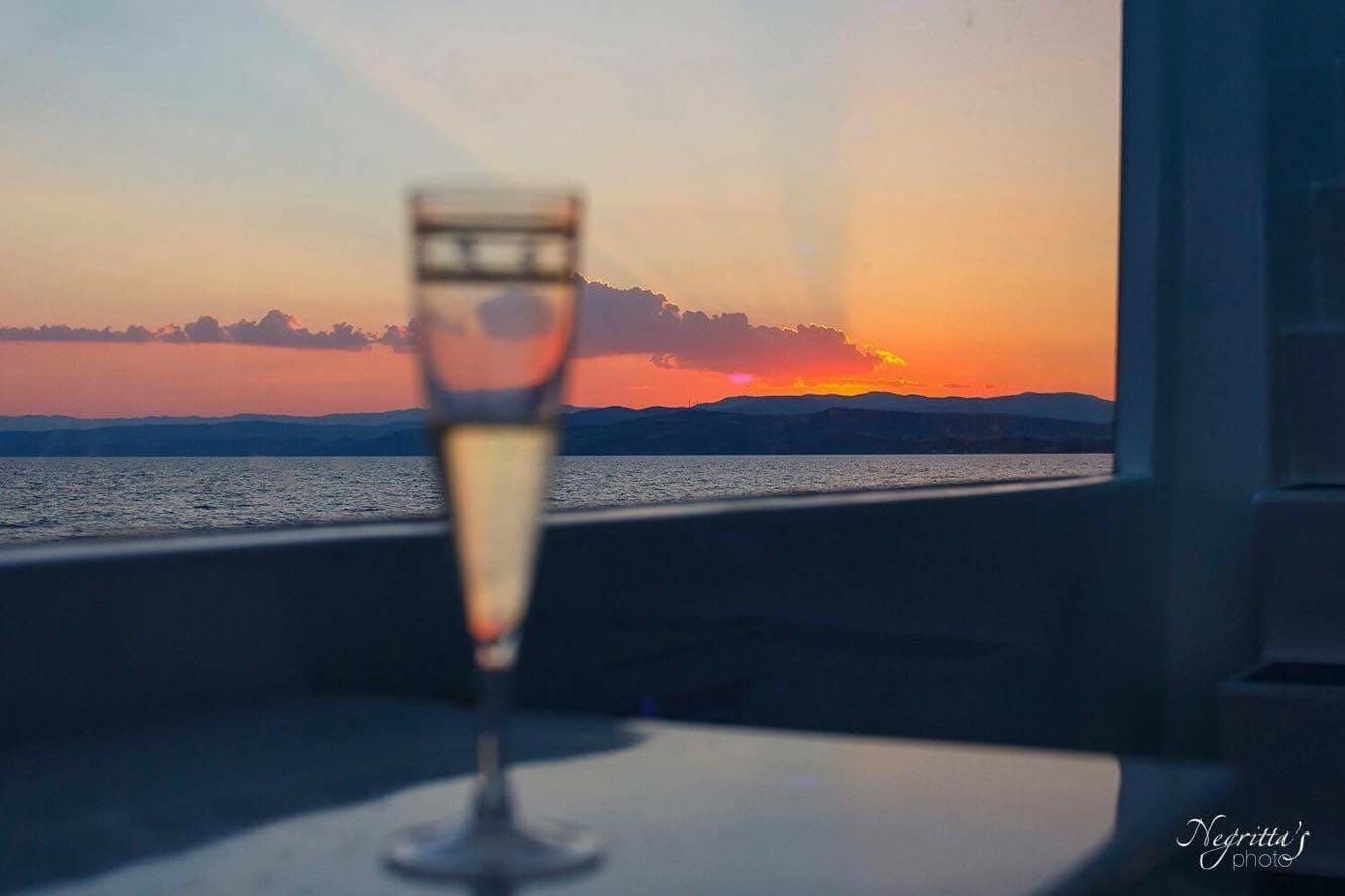 Champagne on boat deck at sunset over Aegean Sea, cruise vibe