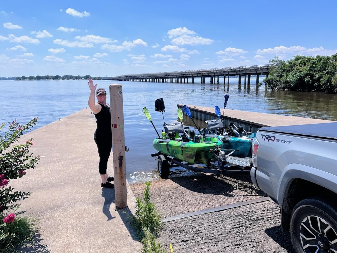 Kayak launch ramp with trailers and angler prepping by truck