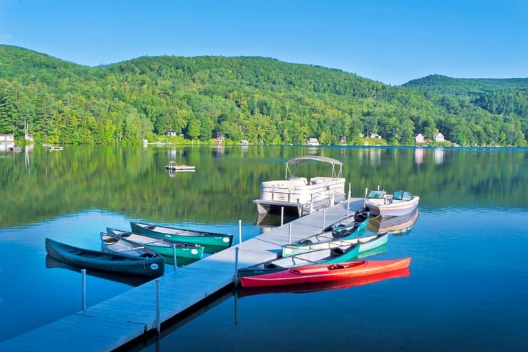 Colorful boats moored at Lake Morey dock with mountain reflections