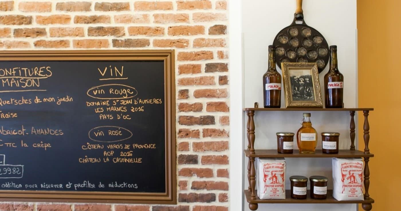 Chalkboard menu and shelf display inside casual creperie