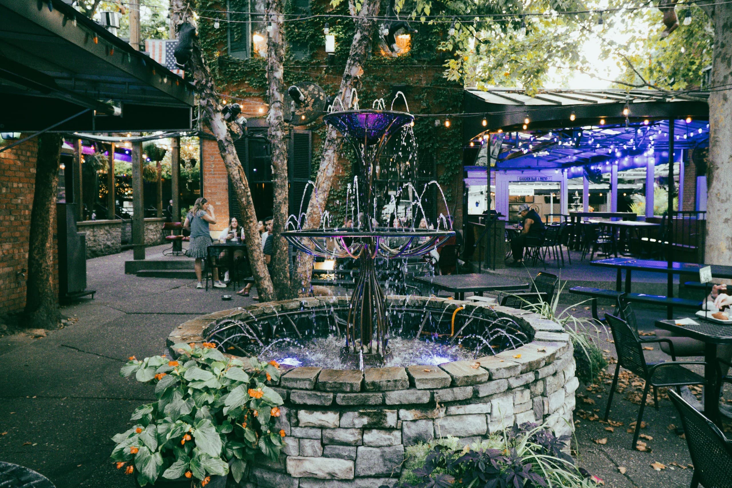Outdoor courtyard fountain with string lights for evening tours