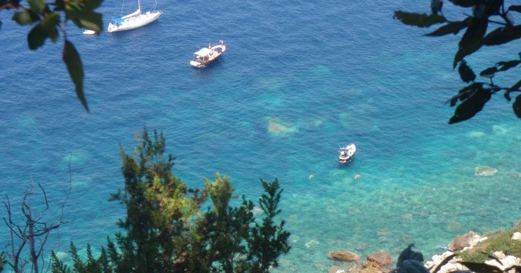 Boats and clear turquoise water seen from cliff near Ponza