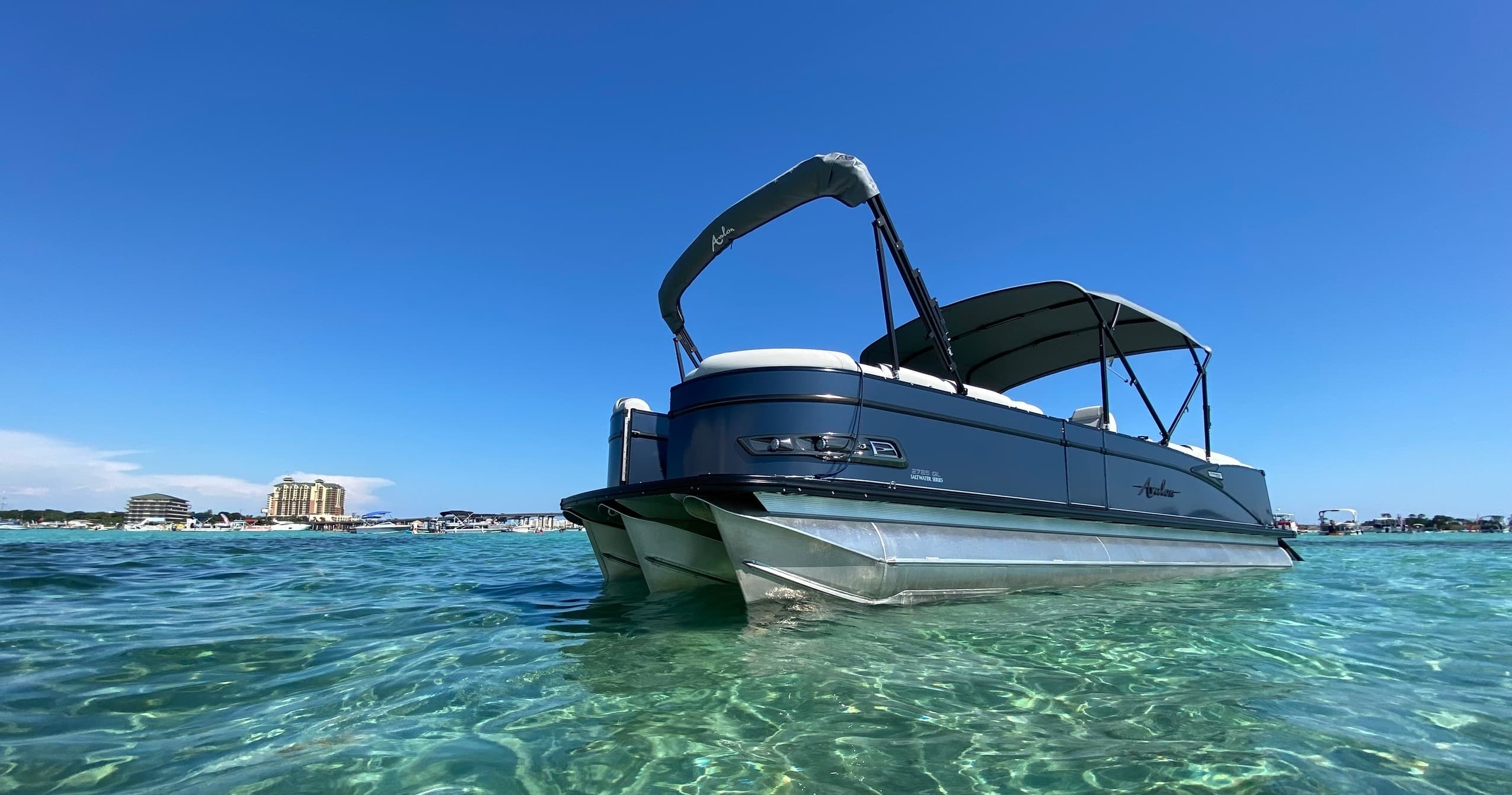 Pontoon boat anchored in crystal clear shallow coastal waters