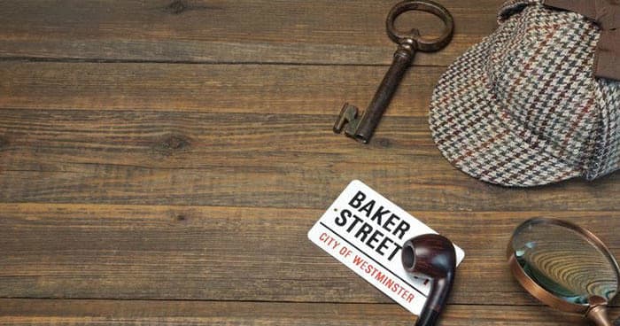 Detective props on wooden table evoking Baker Street mystery