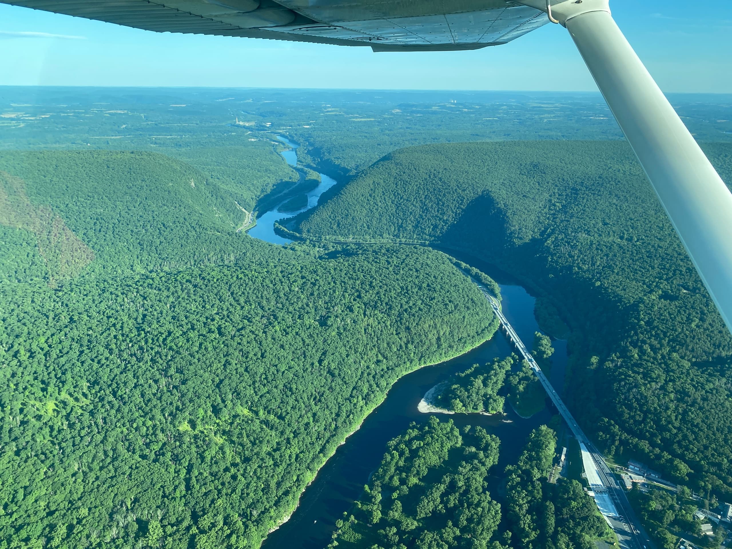 Scenic aerial river canyon over forested mountains in flight