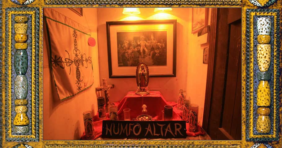 Dimly lit voodoo altar inside museum room, ritual display
