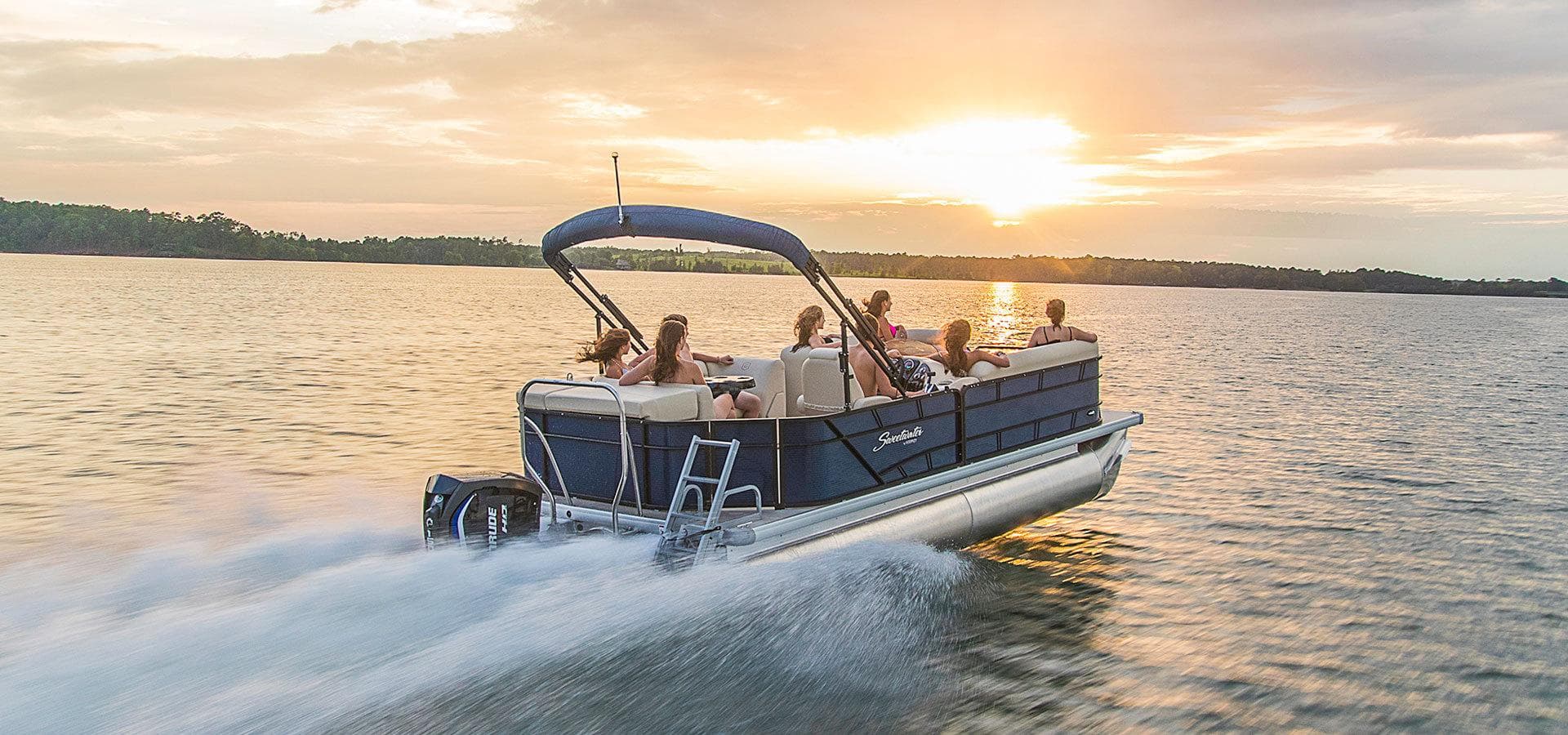 Family enjoying pontoon lake cruise at warm sunset light