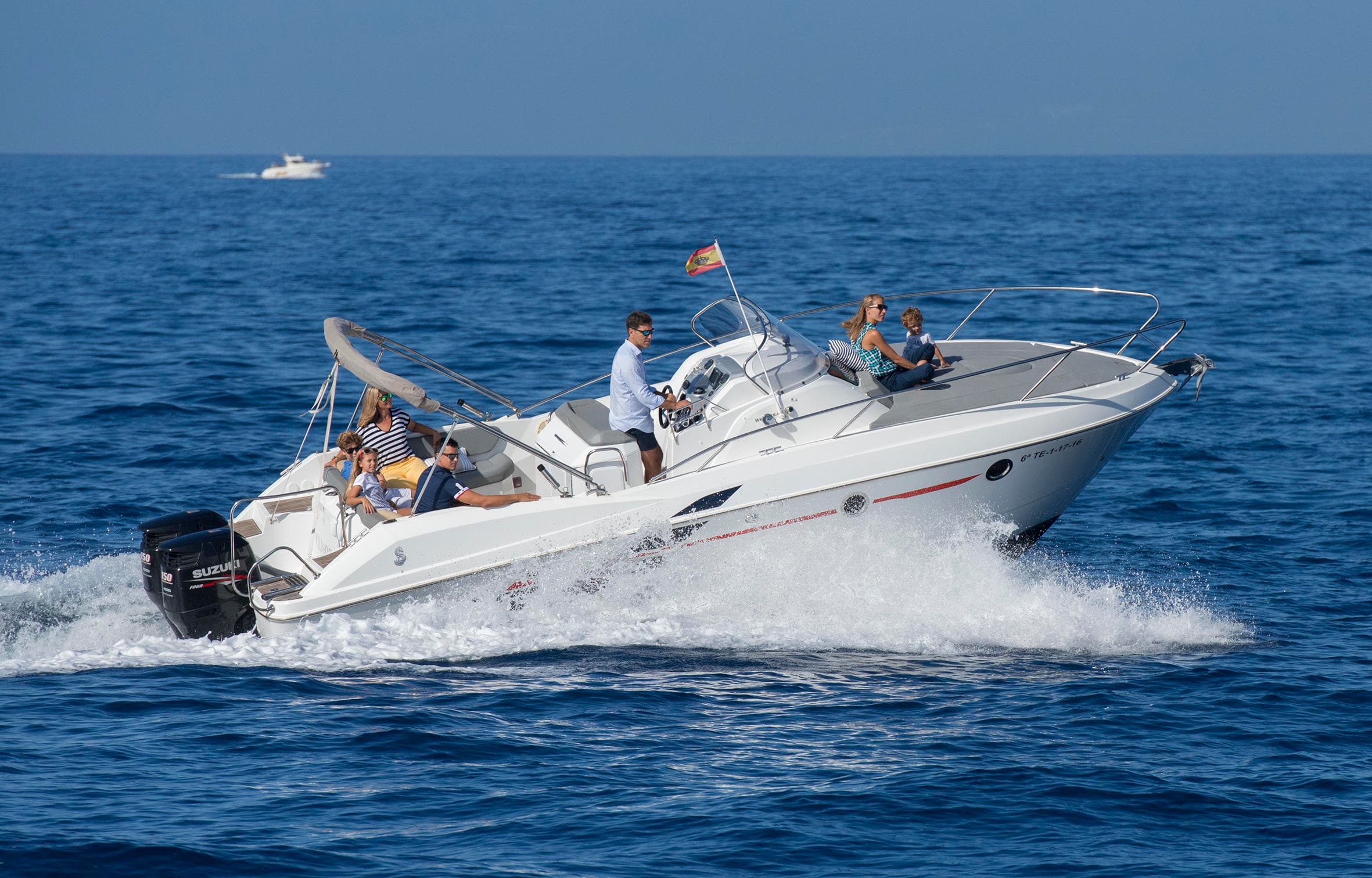 Powerboat speeding across open sea with passengers on deck