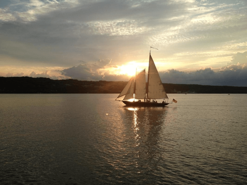 Sailboat cruising at sunset on open coastal waters