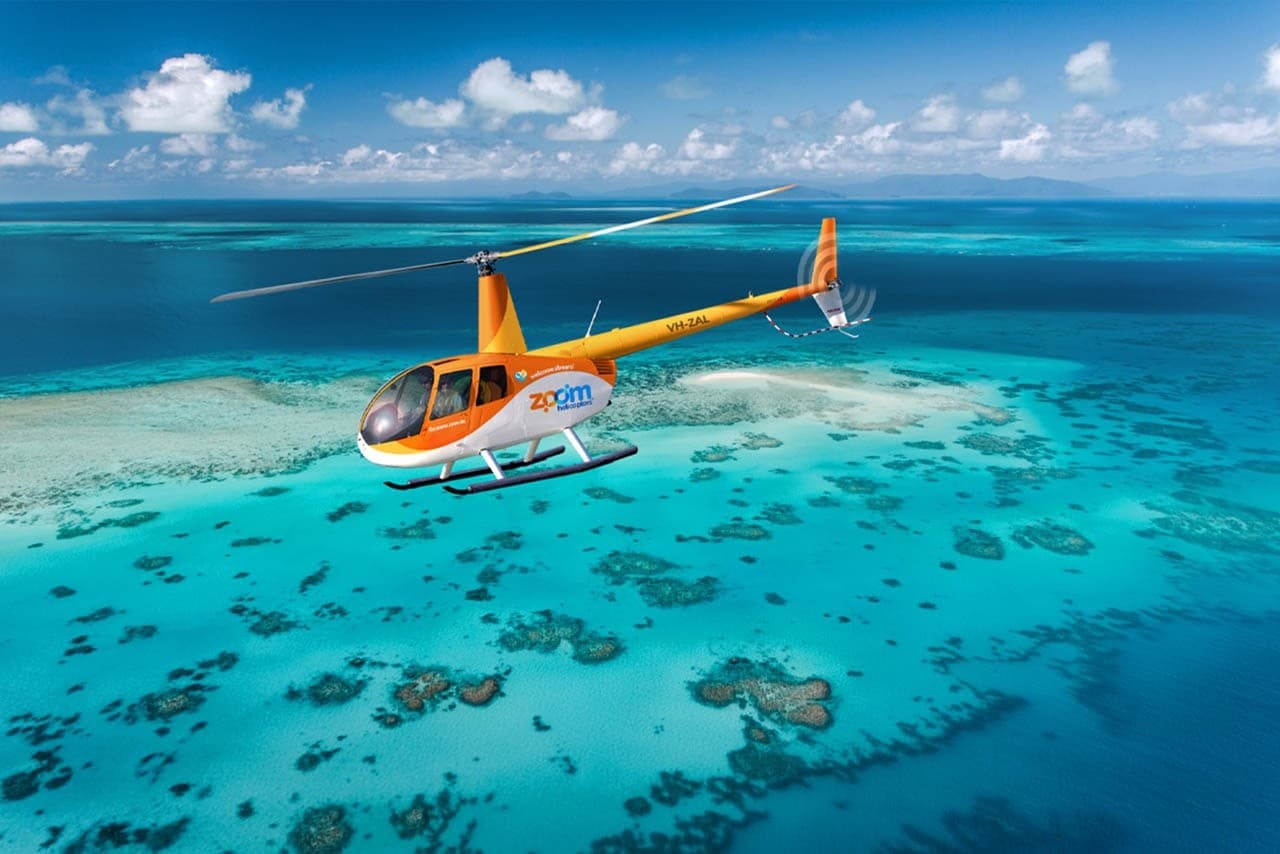 Pilot cockpit view of aerial tour over blue ocean and reef