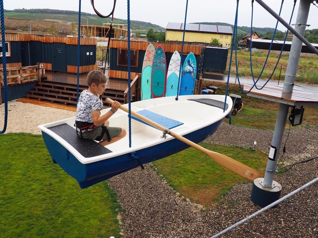 Child in suspended boat swing on aerial ropes park at Frankenturm