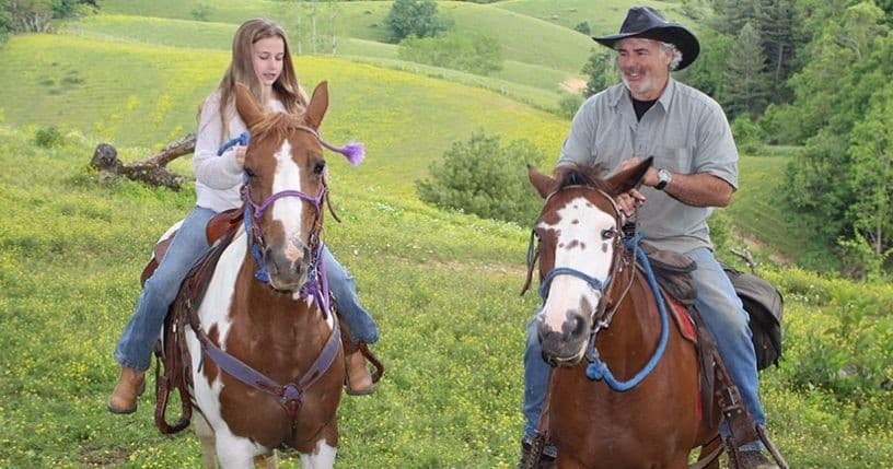 Two horseback riders on painted horses in green hills