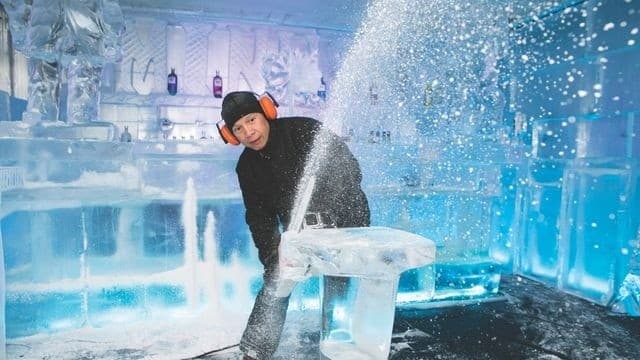 Guide chiseling ice sculpture inside minus5 ice bar, action shot