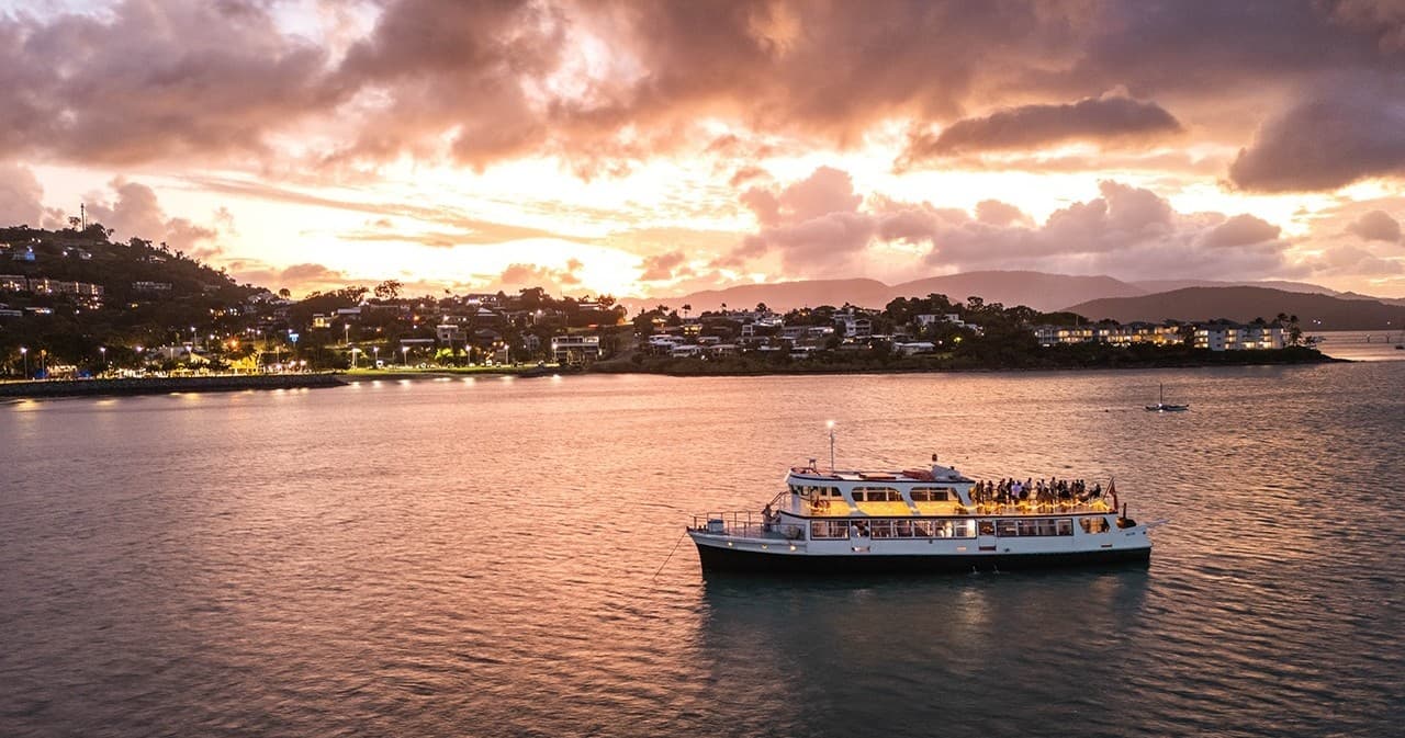 Sunset sightseeing cruise in coastal harbor with scenic skyline