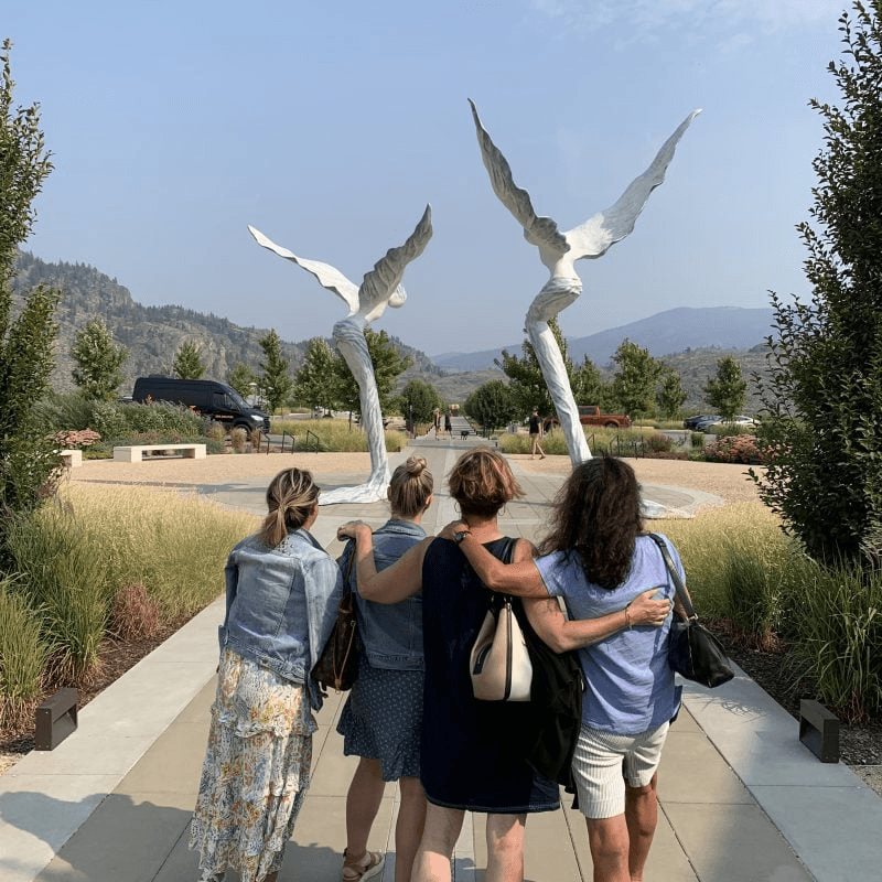 Friends admiring outdoor wine sculptures with valley views