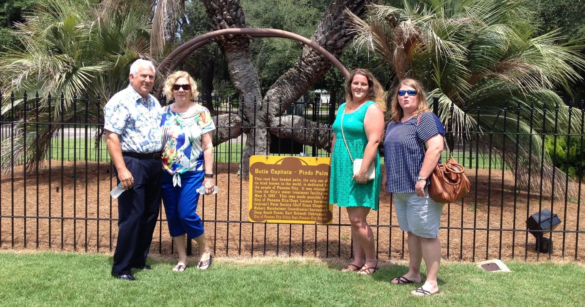 Group posing by historic palms and marker in Panama City