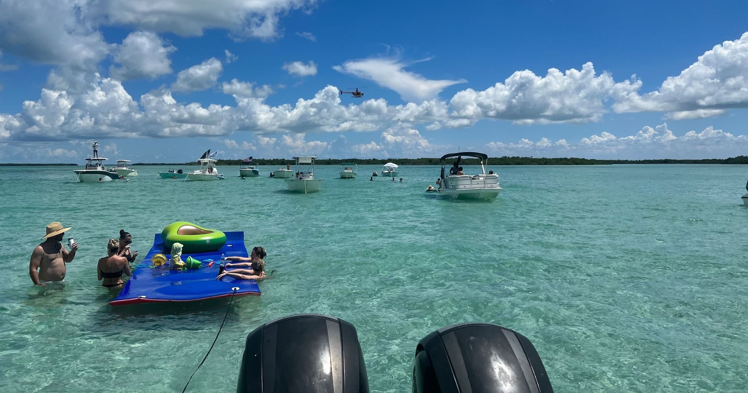 Boaters and families lounging at shallow turquoise sandbar, Florida Keys