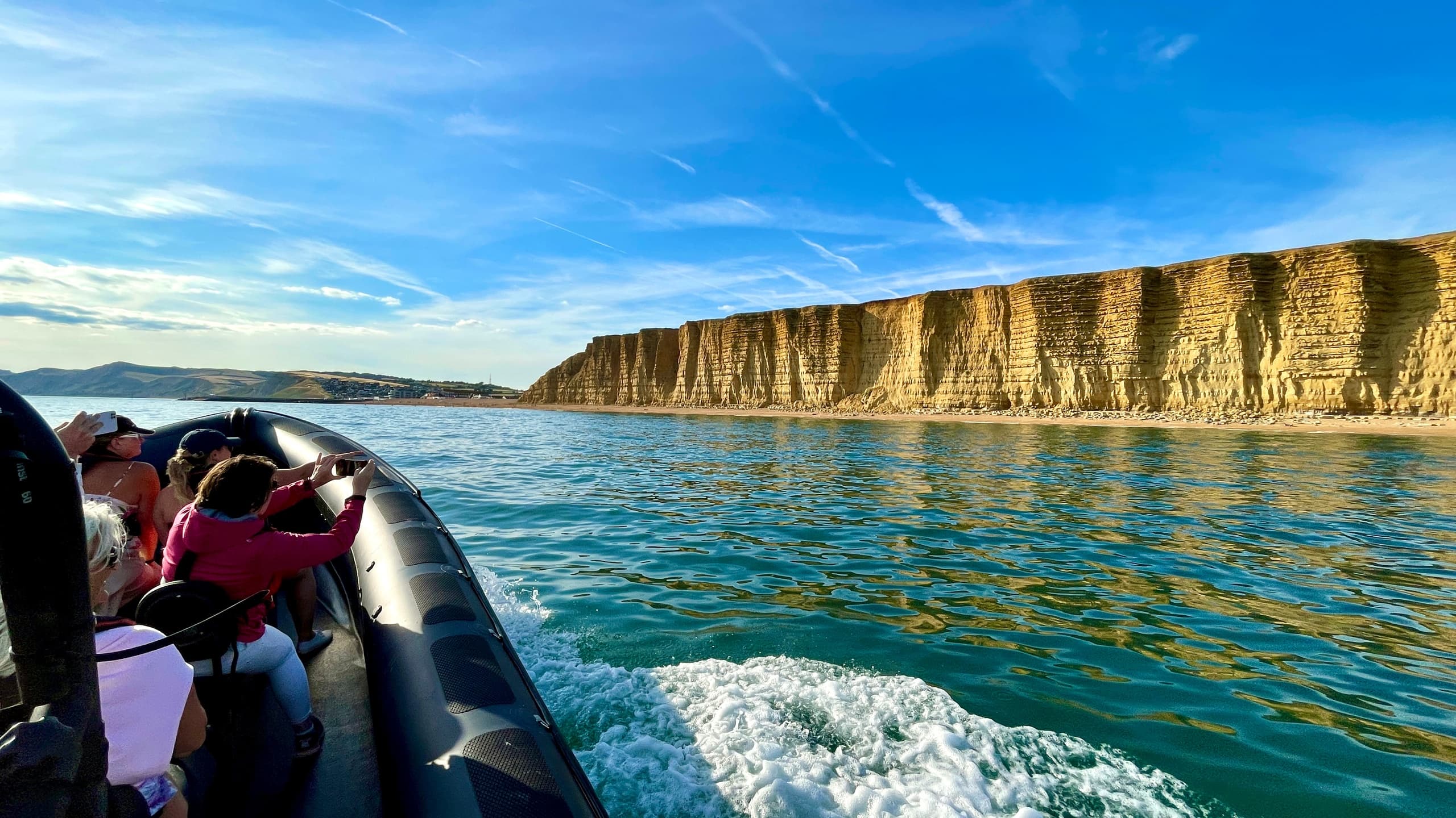 View from RIB toward chalk cliffs and blue sea in Lyme Bay